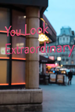 a blurry photo of a building with a sign that says you look extraordinary