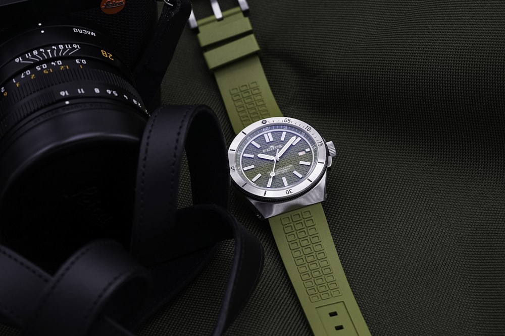 a watch sitting on top of a green strap