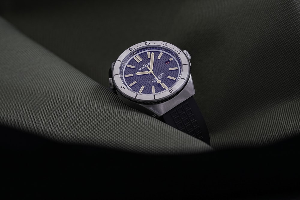 a watch sitting on top of a piece of cloth