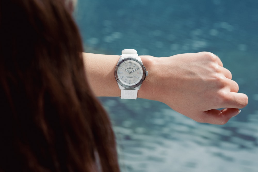a woman wearing a white watch on her wrist