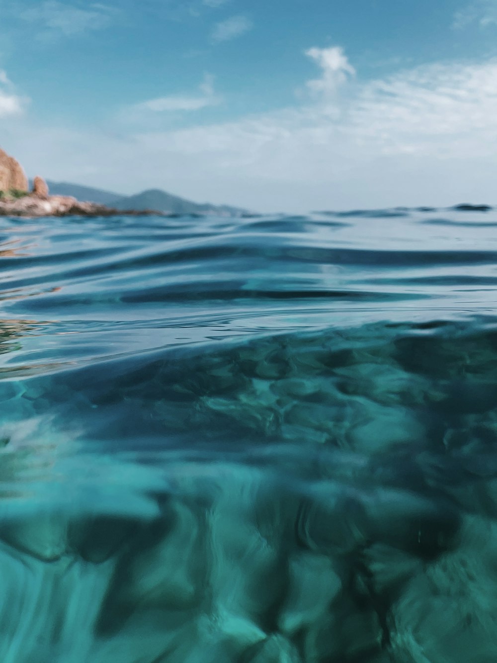 a body of water with rocks in the background