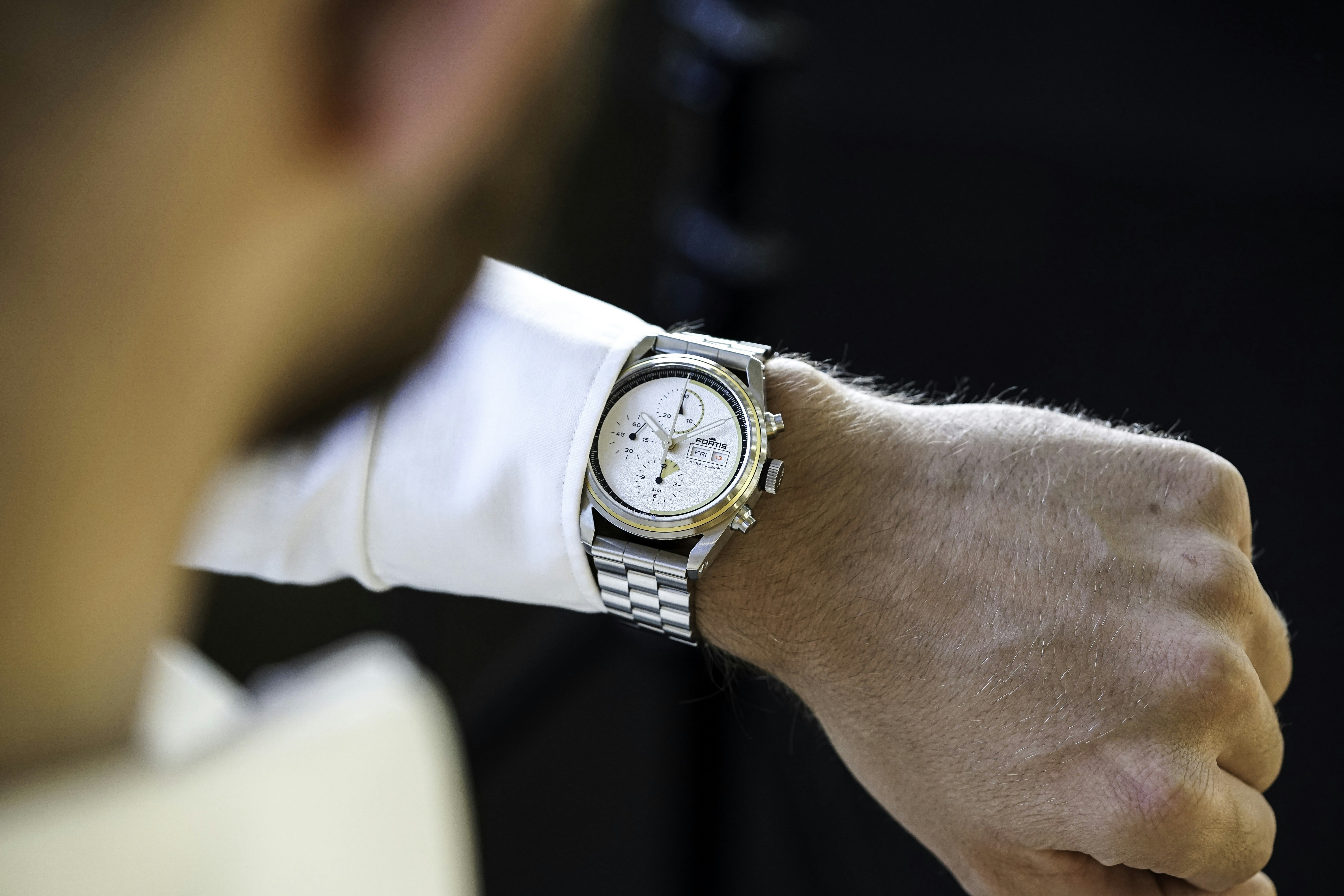 Person wearing gold luxury watch close-up