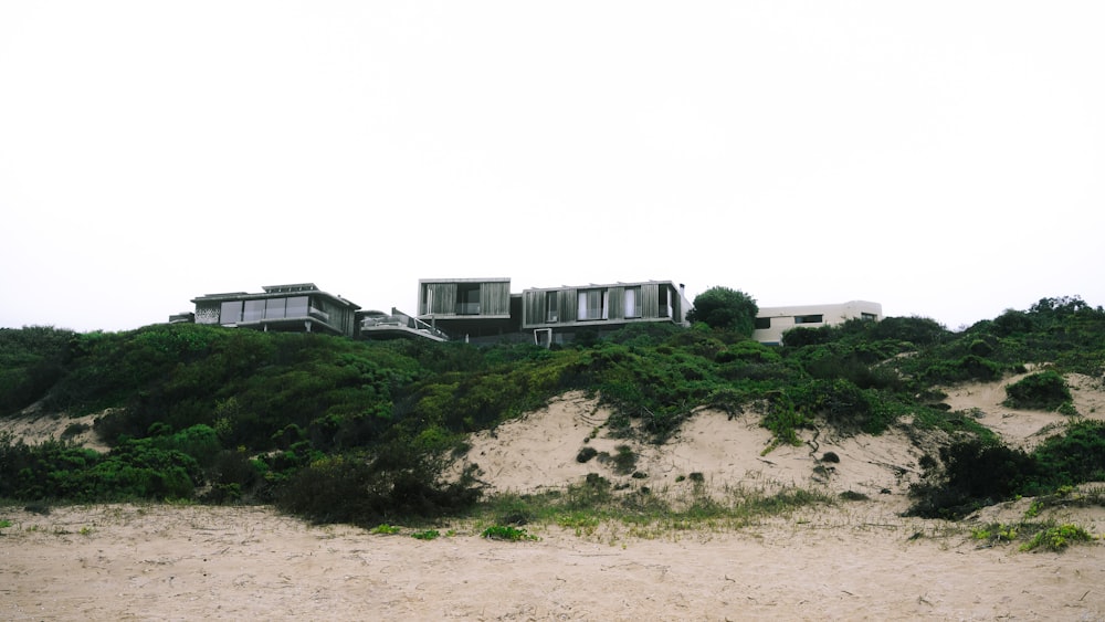 a house sitting on top of a sandy hill