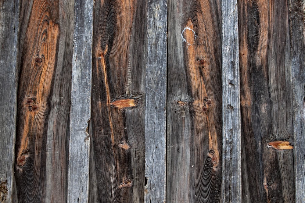 a close up of a wooden fence with peeling paint