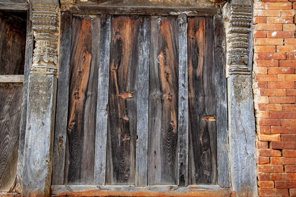 a close up of a wooden door on a brick building