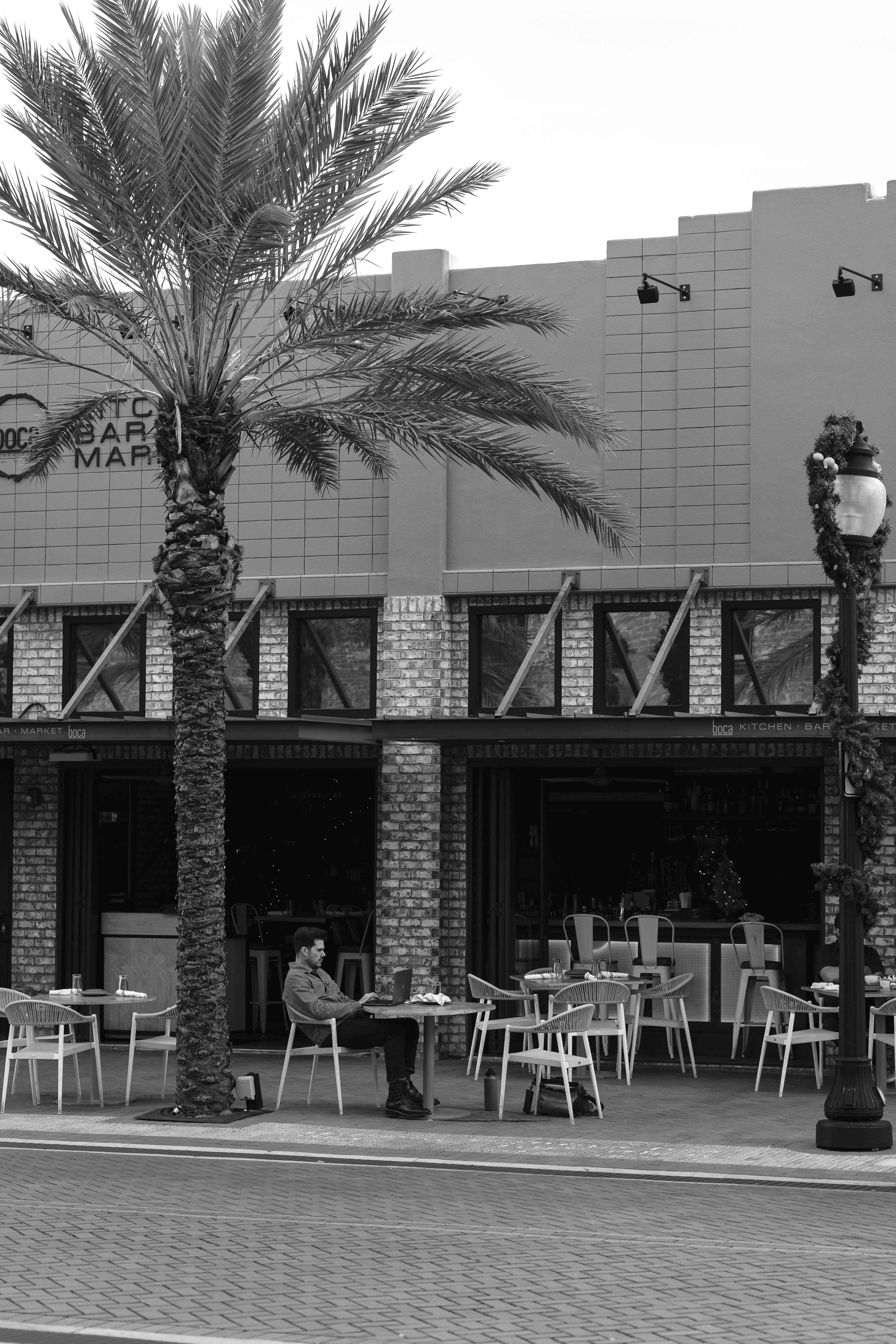 Caribbean male entrepreneur working on laptop at outdoor cafe