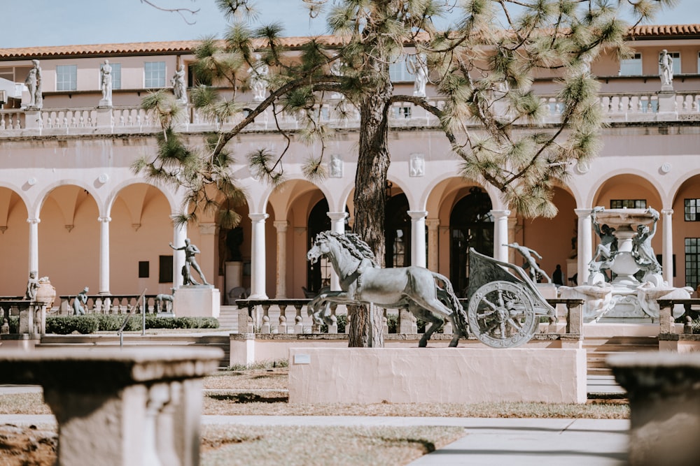 a statue of a horse drawn carriage in front of a building