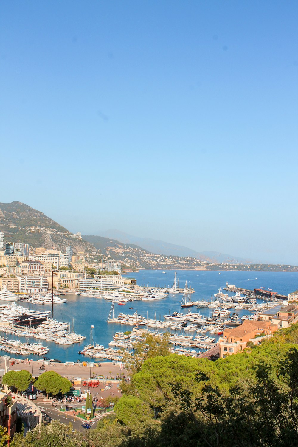 a harbor filled with lots of boats next to a hillside