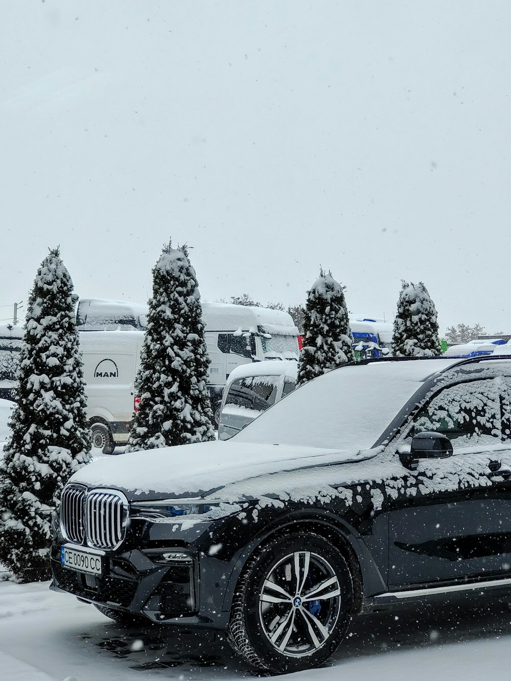 Un'auto è coperta di neve in un parcheggio