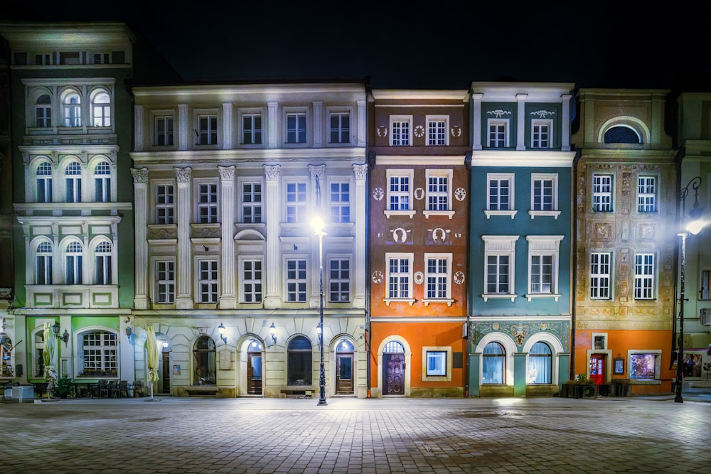 a row of multi - colored buildings lit up at night