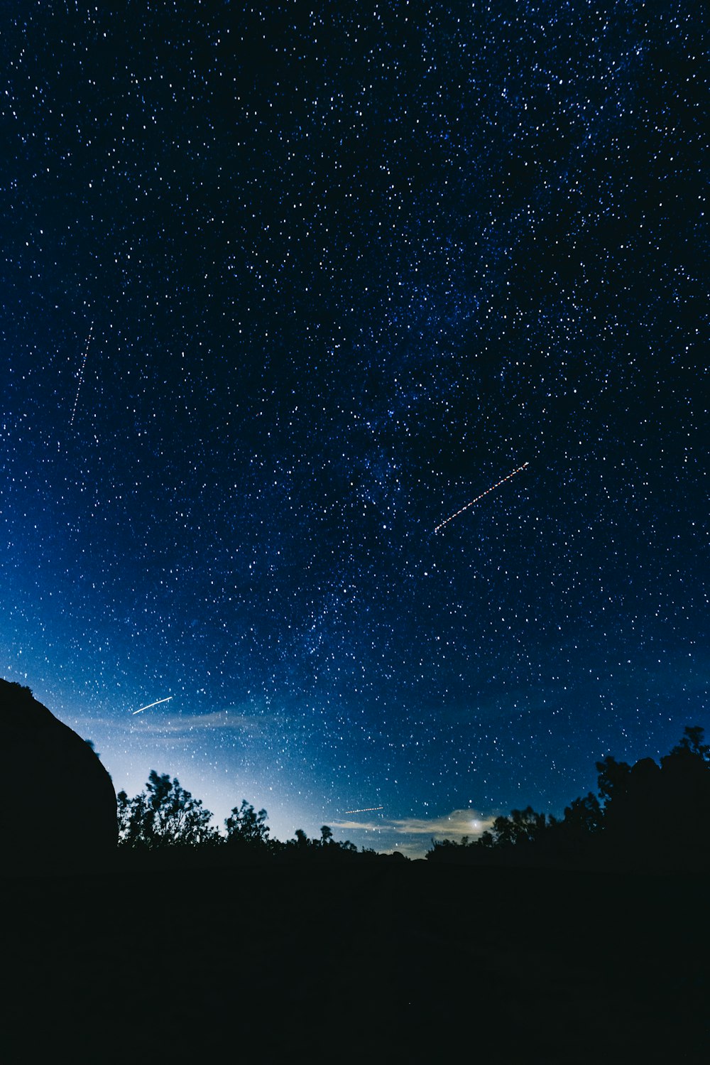 a night sky with stars and a silhouette of a person