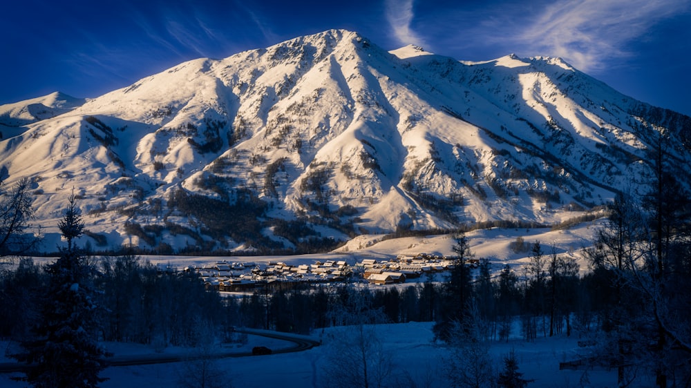 a snow covered mountain with a village below