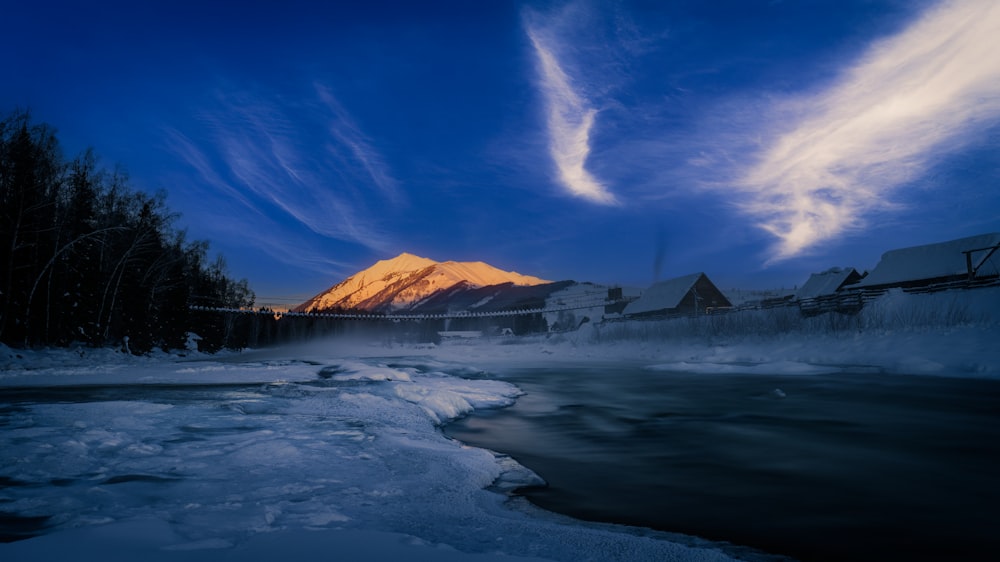 a snowy river with a mountain in the background