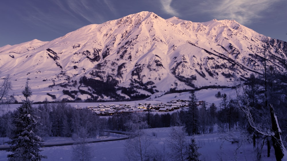 a snow covered mountain with a village in the foreground