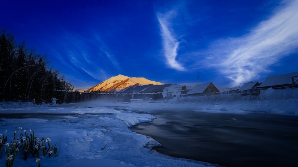 a snow covered river with a mountain in the background