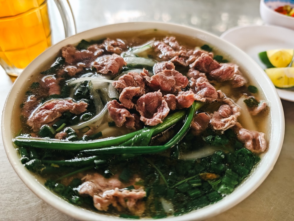 a bowl of soup with meat and greens