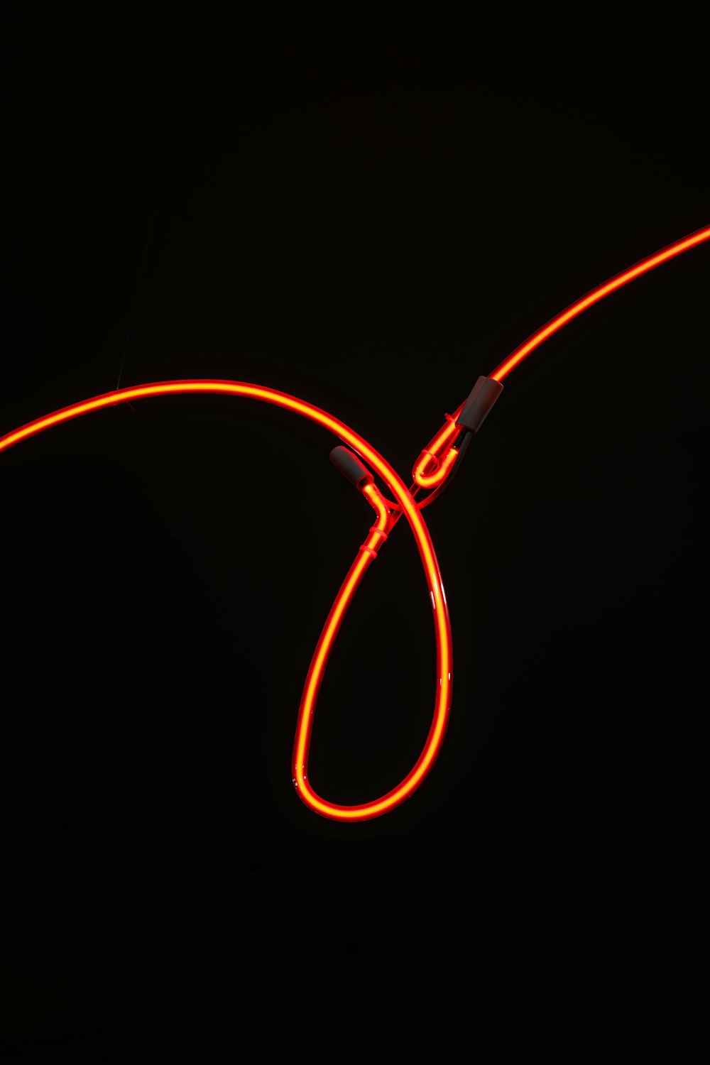 a pair of neon orange cords on a black background
