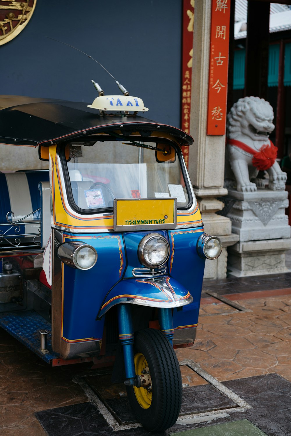 a small blue and yellow vehicle parked in front of a building