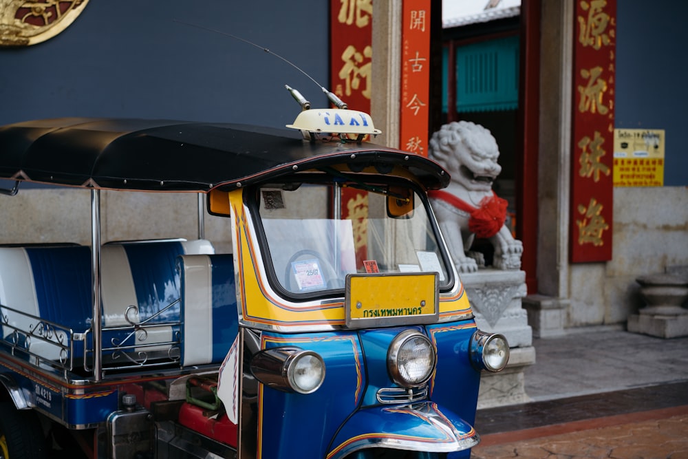 a small blue and yellow vehicle parked in front of a building