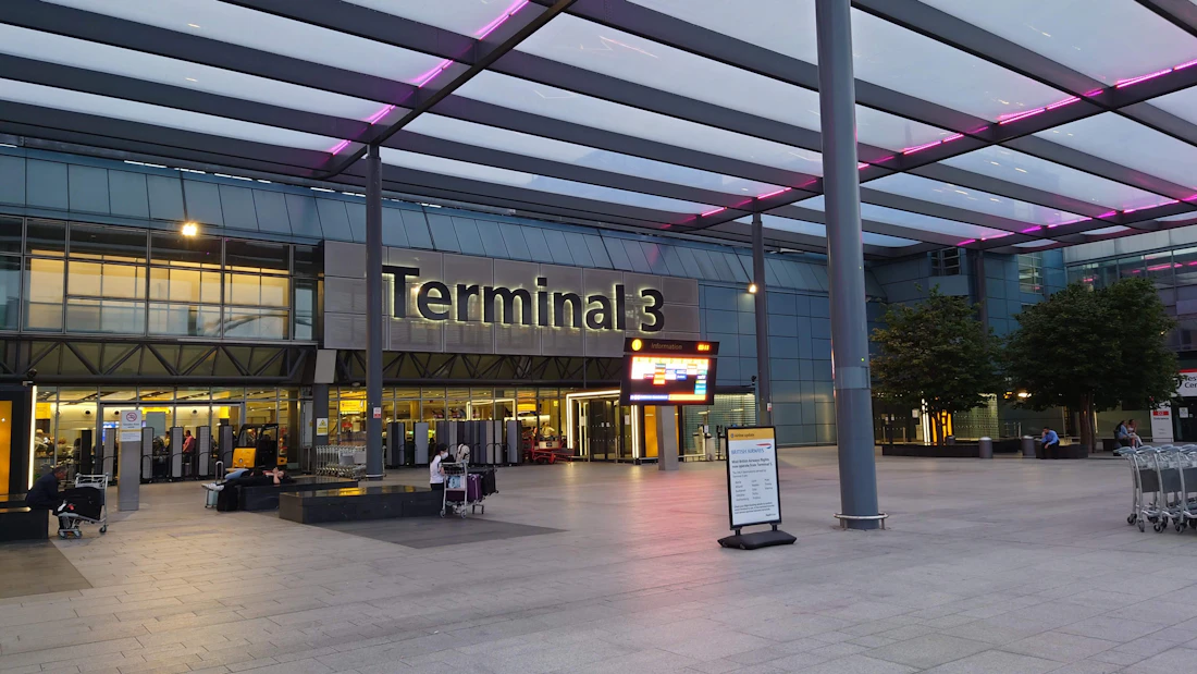 The exterior of an airport Terminal 3 building at dusk
