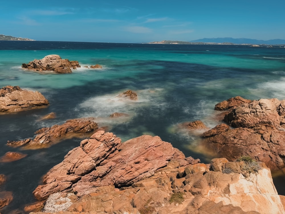 a rocky beach with clear blue water