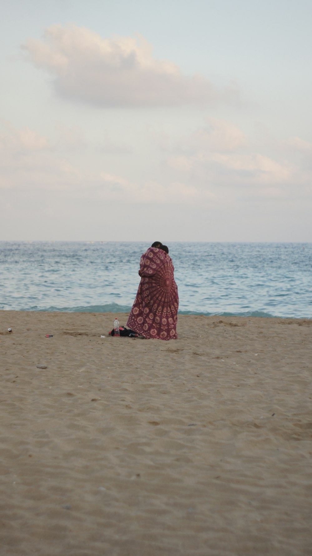 a woman sitting on a beach next to the ocean