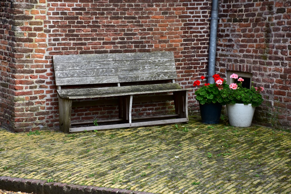 a wooden bench sitting next to a brick wall