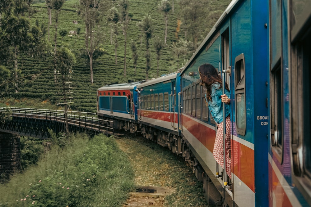 a woman standing on a train looking out the window