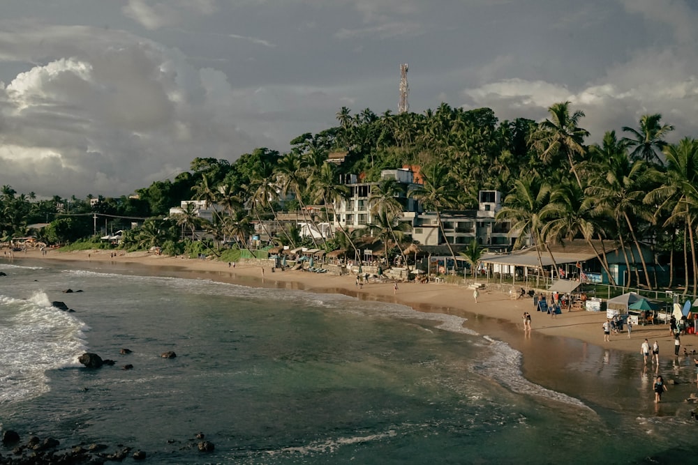 a group of people standing on top of a sandy beach