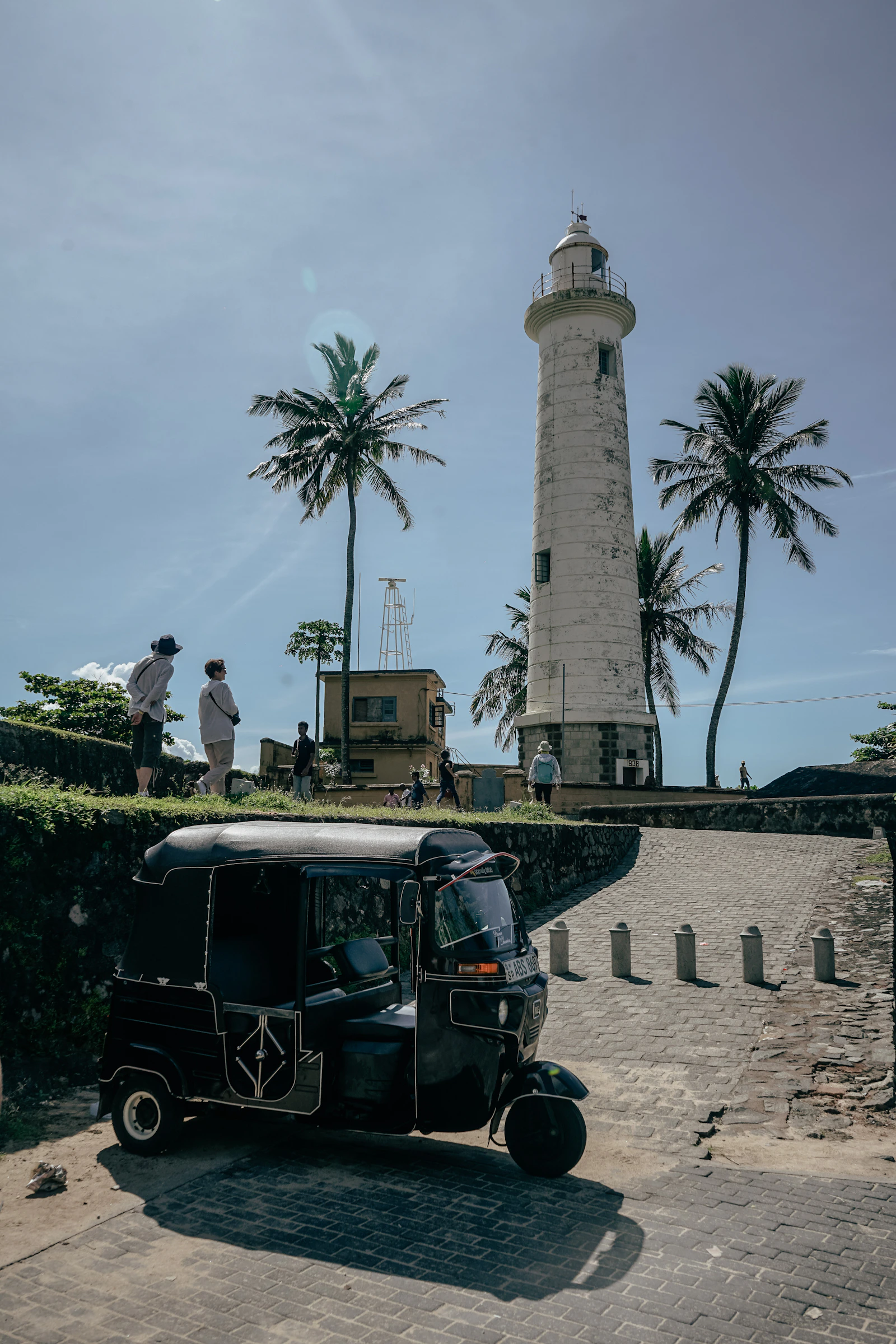 El faro de la fortaleza de Galle con un tuk tuk estacionado adelante