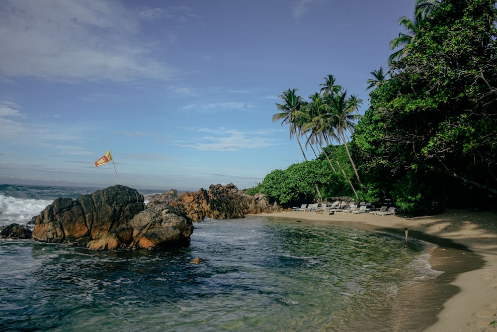 a beach with a rock and a flag on it