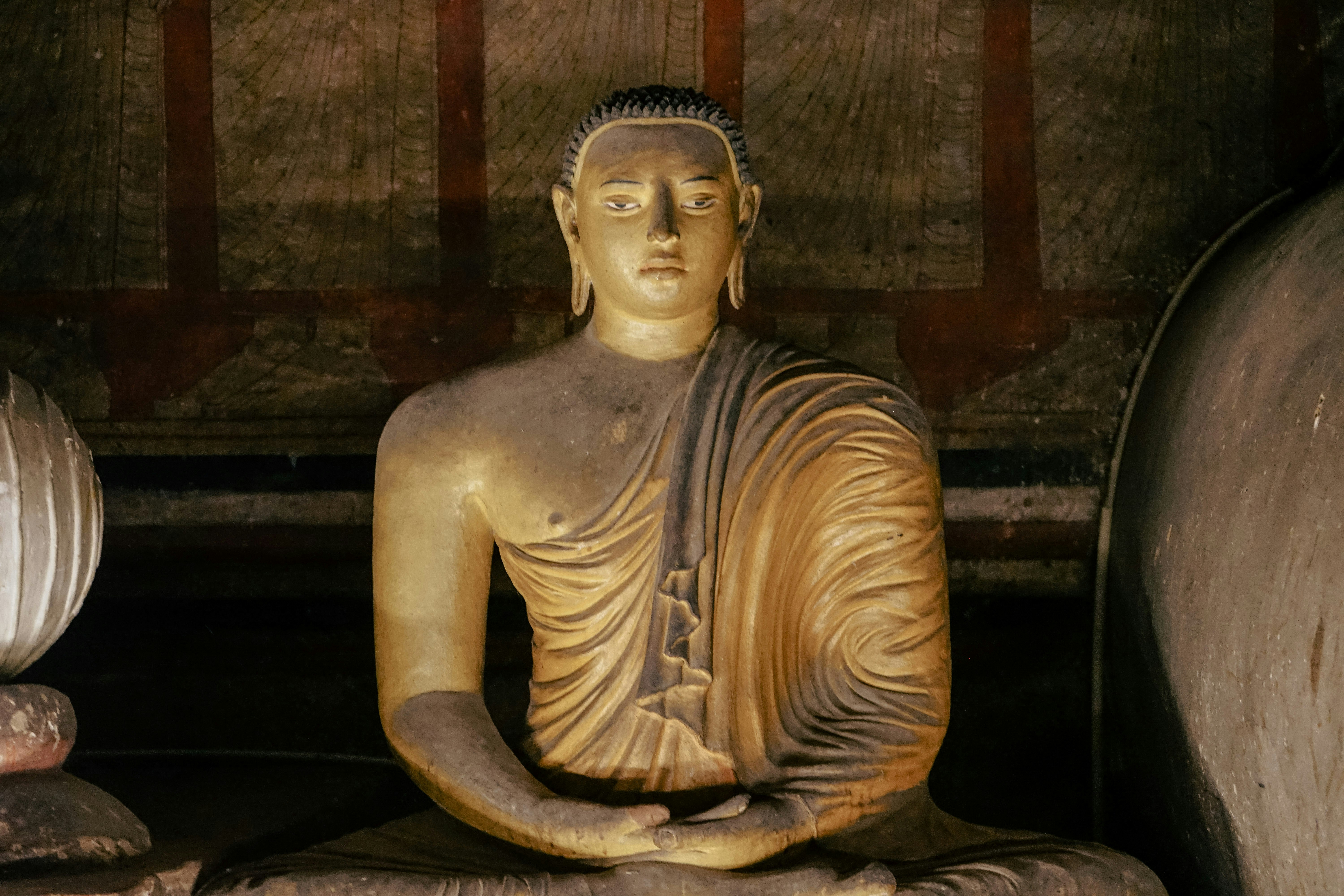 a statue of a buddha sitting in a room, Buddha in Dambulla Cave Temple, Sri Lanka