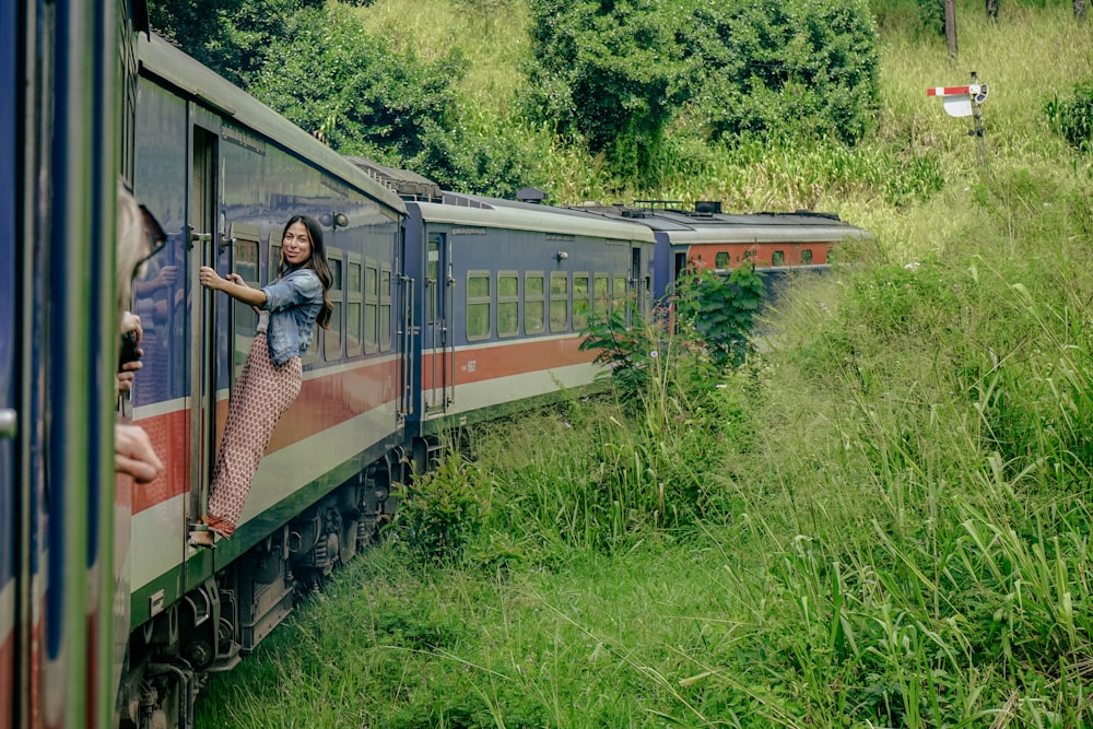 a woman standing on the side of a train