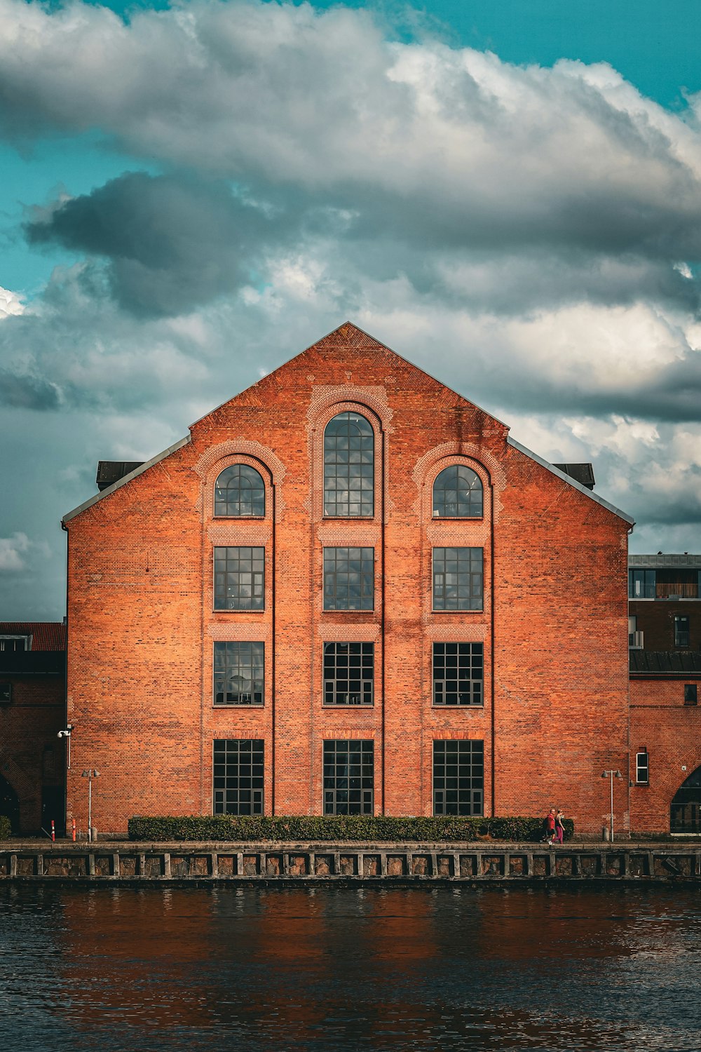 a large brick building sitting next to a body of water