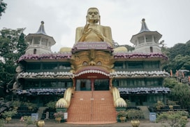 a large golden buddha statue sitting in front of a building