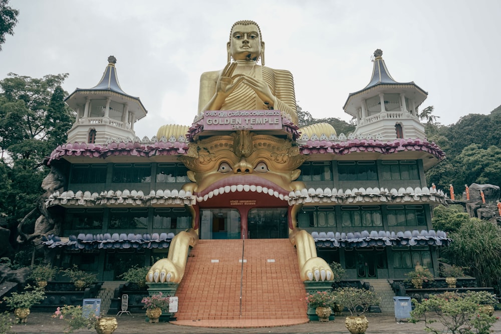 a large golden buddha statue sitting in front of a building