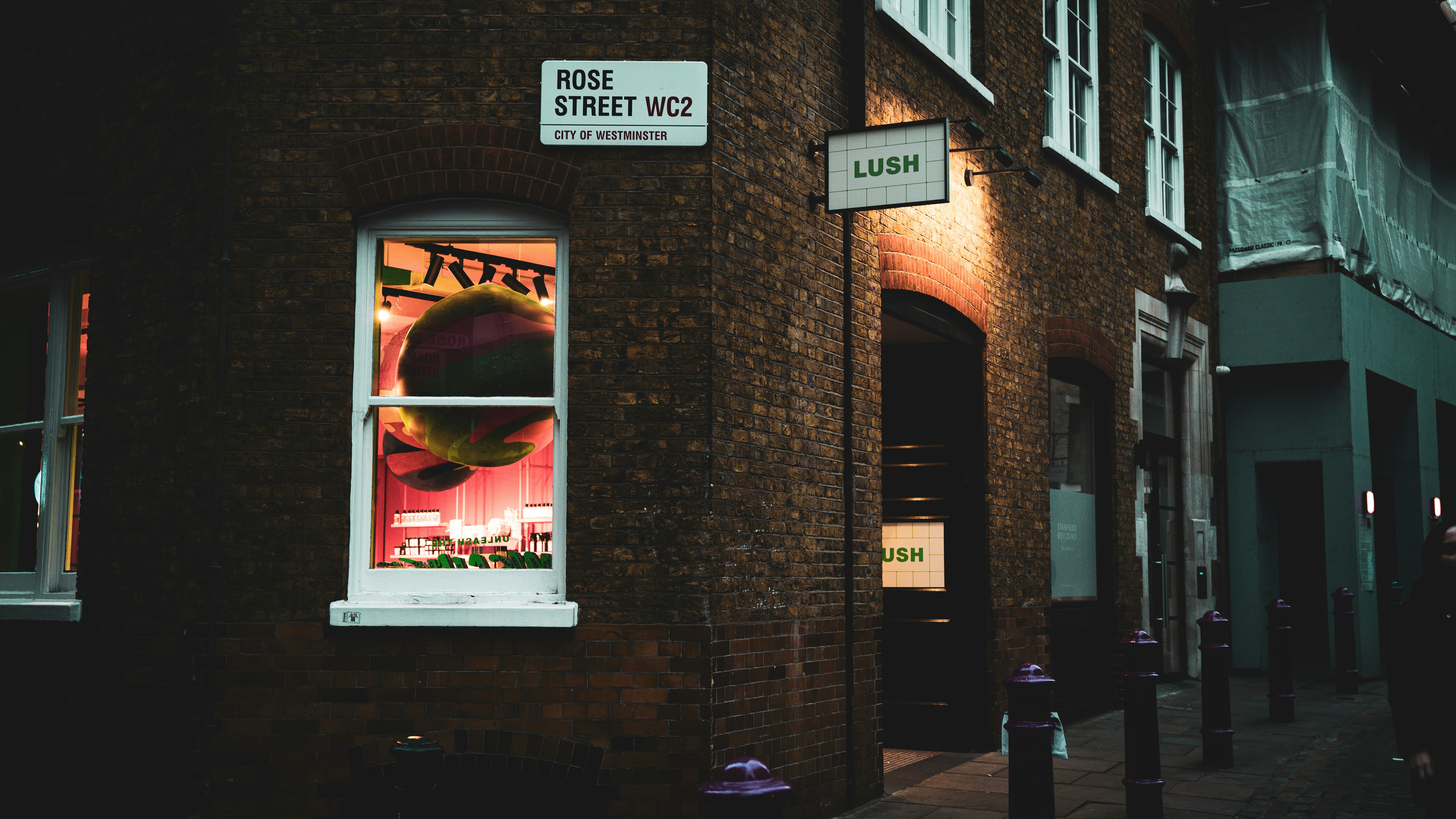 a brick building with a window with a poster on it