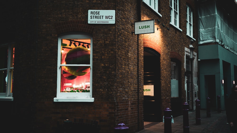 a brick building with a window with a poster on it