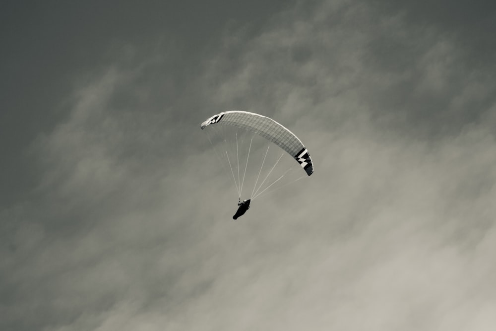 a person is parasailing in the air on a cloudy day