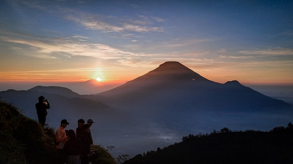 a group of people standing on top of a mountain