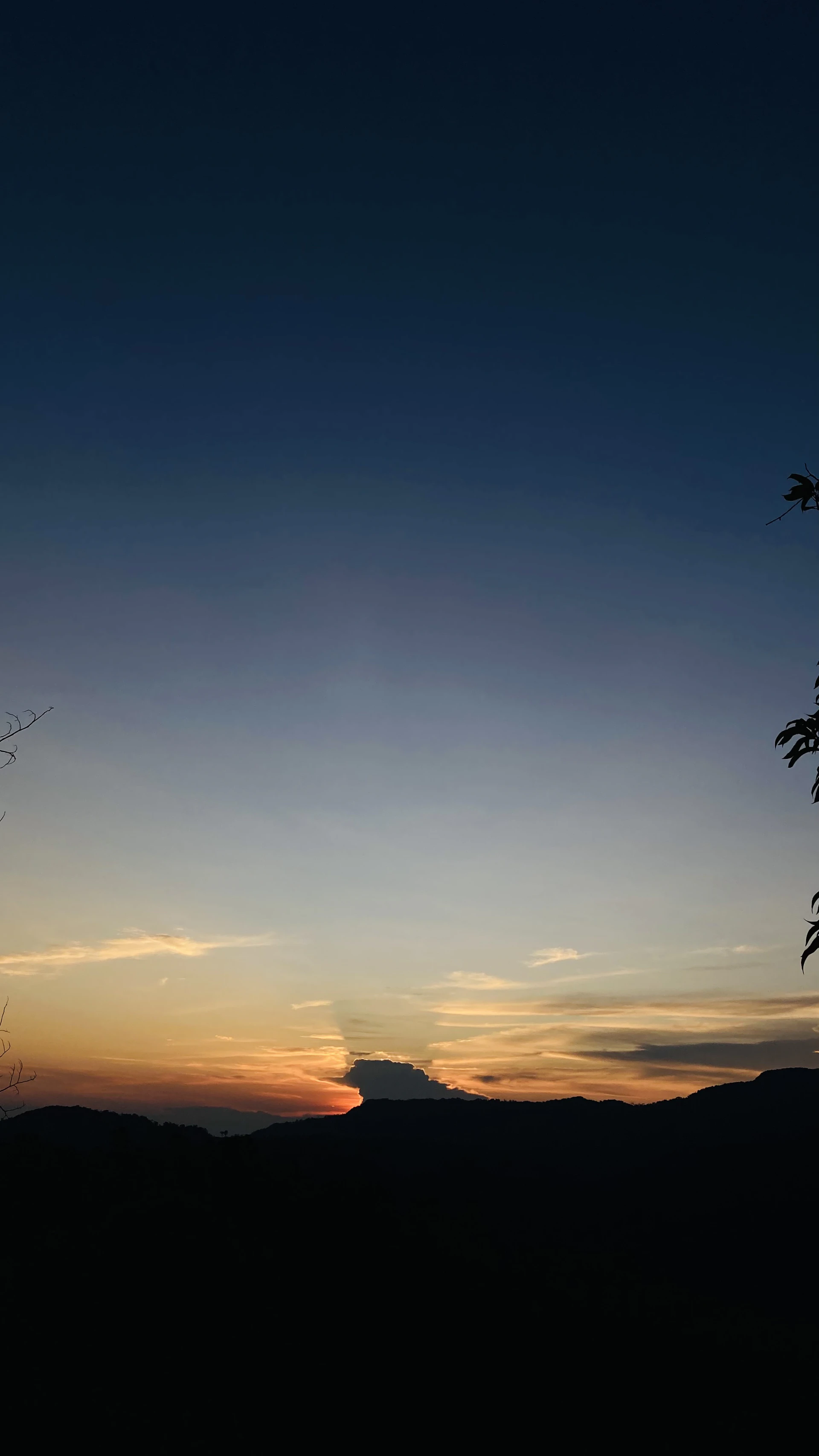 the sun is setting over a mountain range