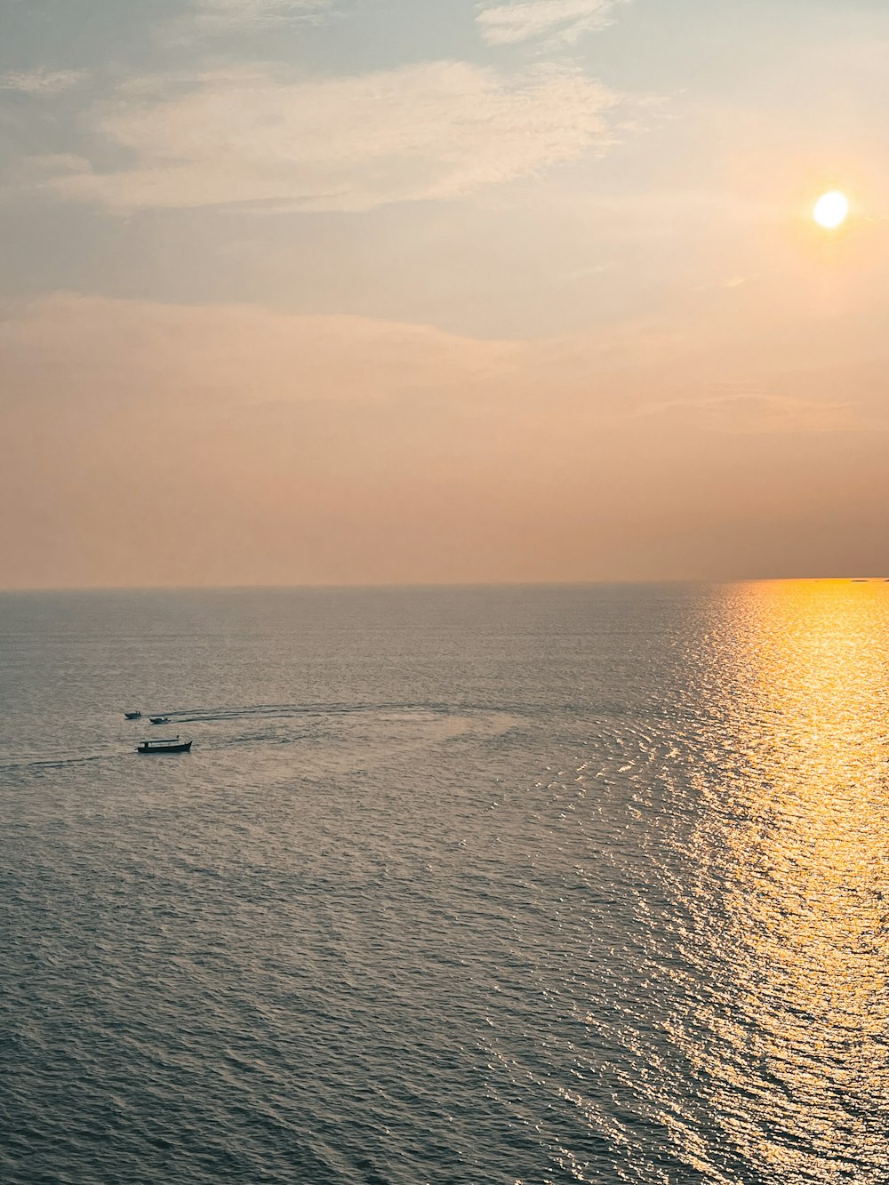 a couple of boats floating on top of a large body of water