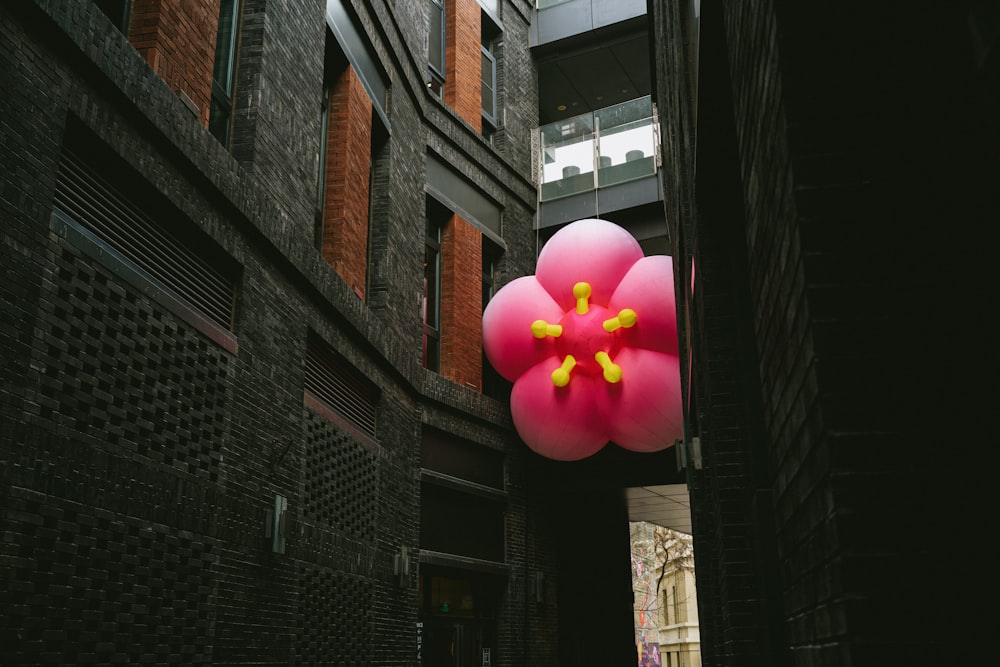 a balloon shaped like a flower hanging from a building