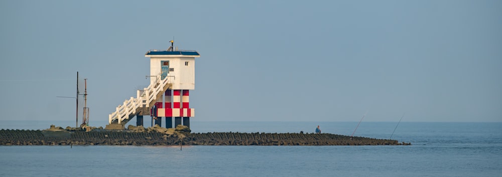 a lighthouse on a small island in the middle of the ocean