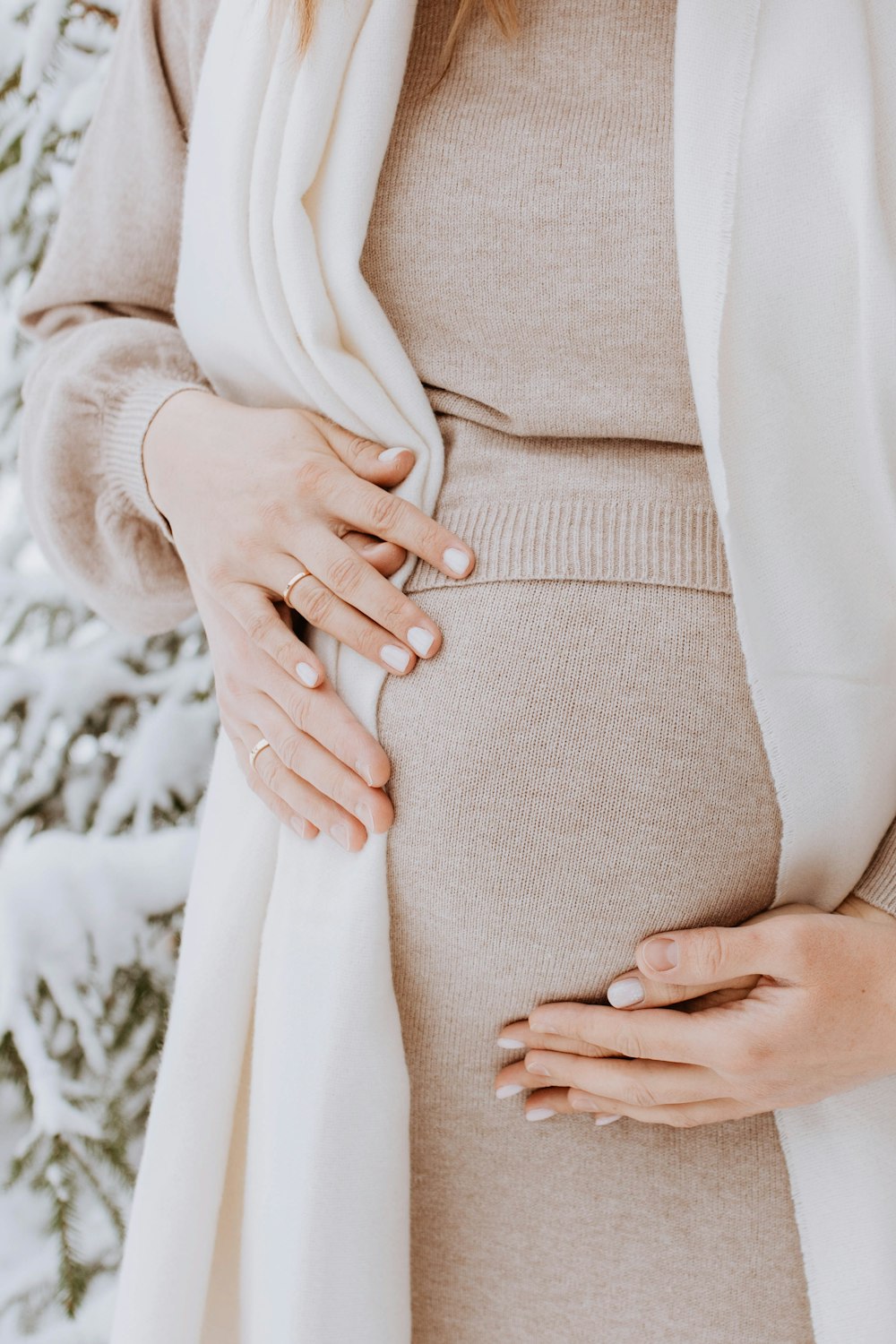 a pregnant woman wearing a white scarf around her waist