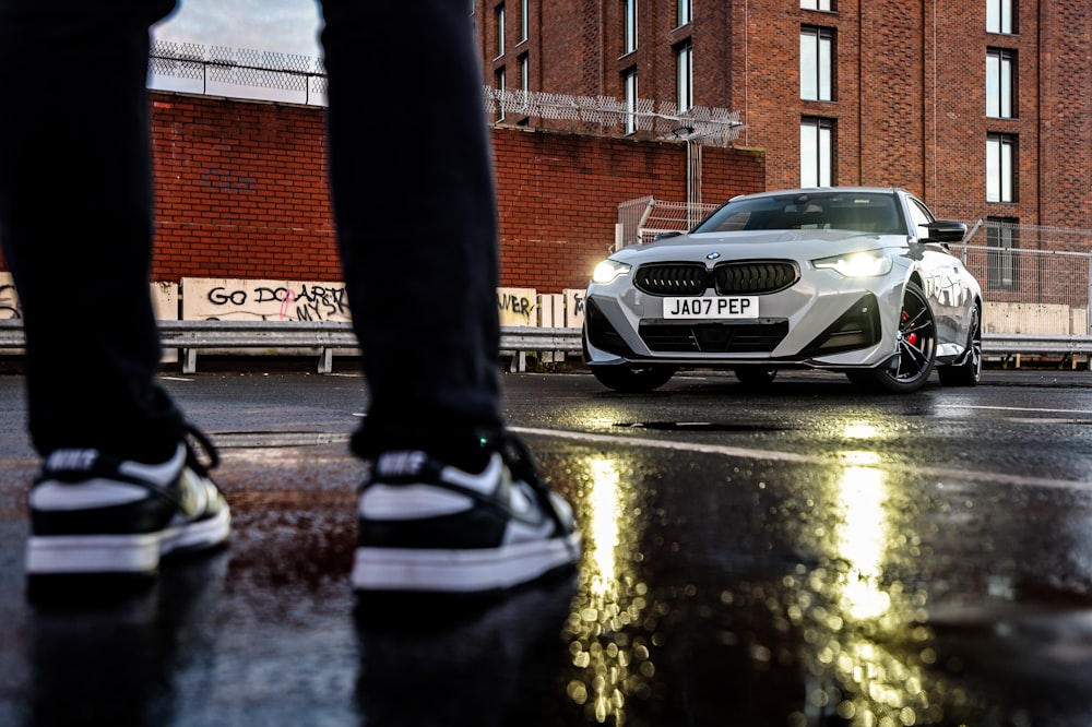 a person standing in front of a white car