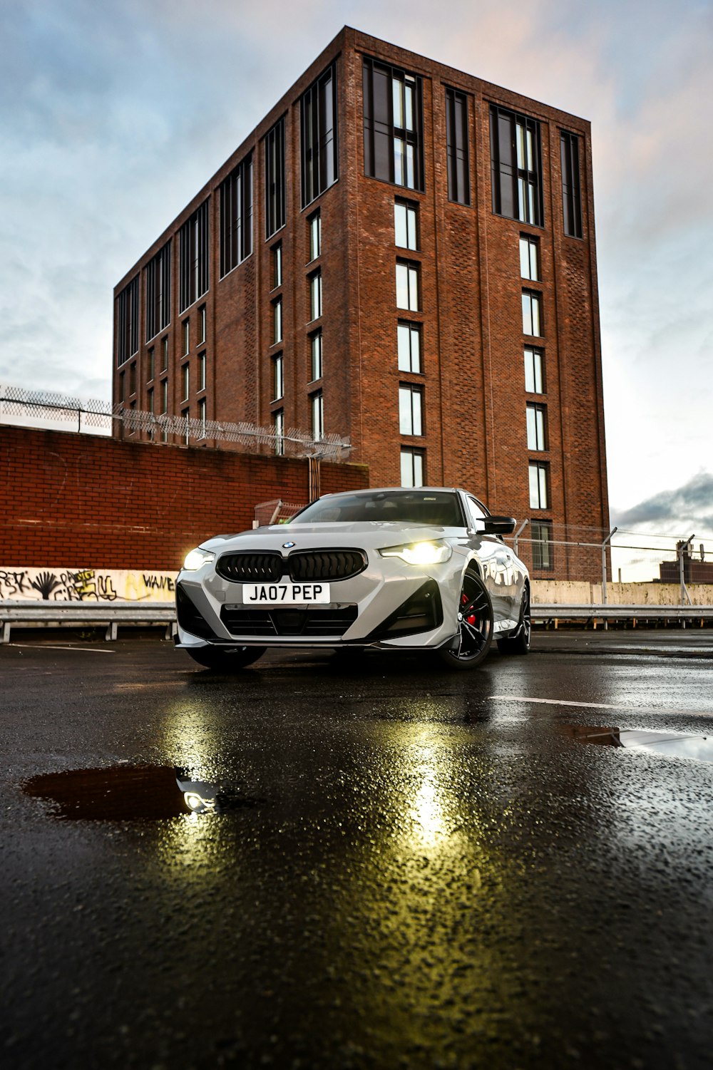 a white car parked in front of a tall building