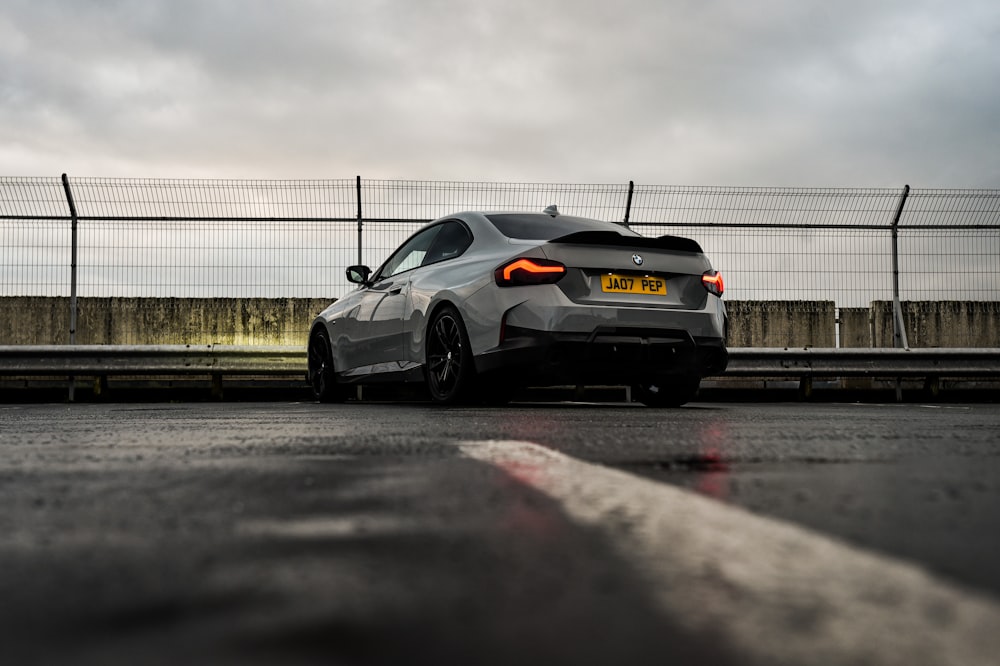 a silver sports car parked on the side of the road