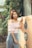 a woman standing next to a refrigerator in a garden