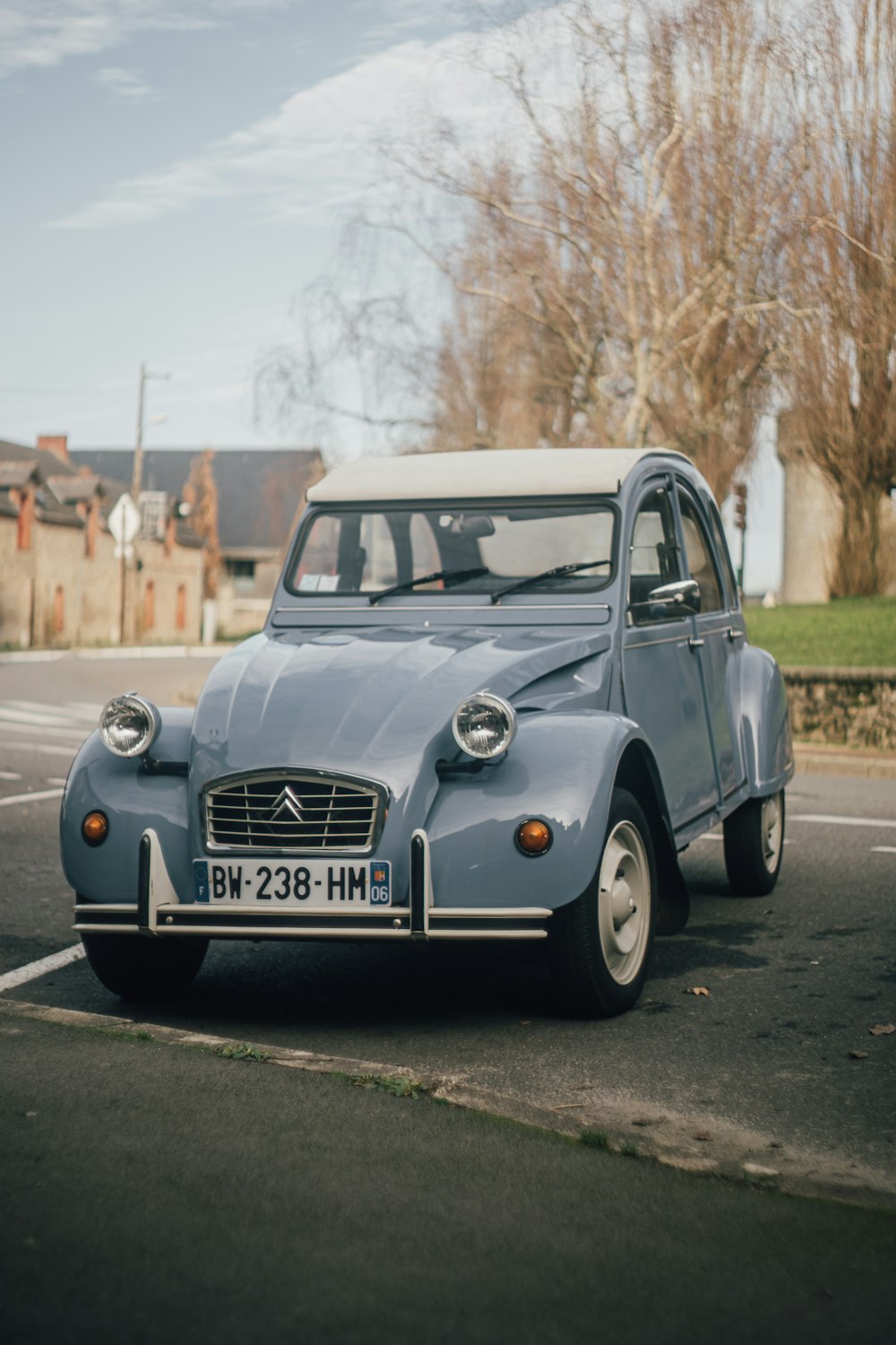 a small blue car parked in a parking lot